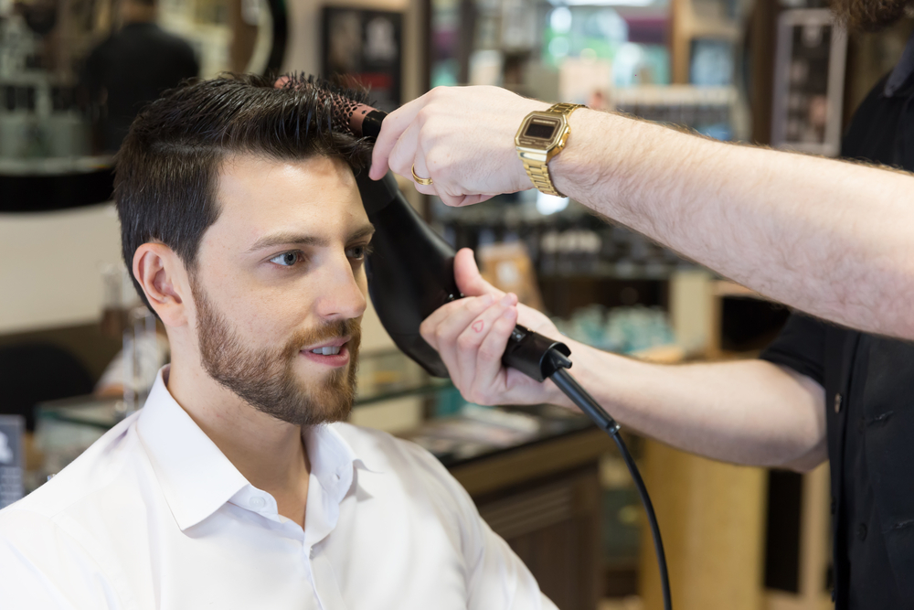 Man getting a haircut at barber shop.