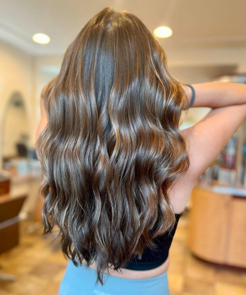 Long wavy brown hair in stylish salon.