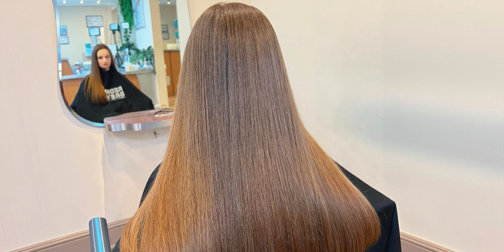 Woman with long straight hair in salon.