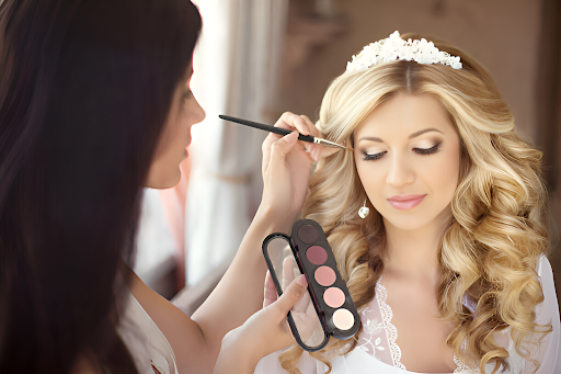 Bride having makeup applied by stylist.